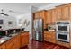 Open-concept kitchen with stainless appliances, wood cabinetry and hardwood floors connecting to living space at 3212 W Fountain Blvd, Tampa, FL 33609