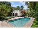 Backyard pool with lush landscaping and detached garage, perfect for outdoor enjoyment at 3212 W Fountain Blvd, Tampa, FL 33609