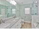 Well-lit bathroom featuring a double vanity with stone countertops and a glass-enclosed shower at 344 Star Shell Dr, Apollo Beach, FL 33572