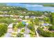 Scenic aerial shot of the property in a leafy neighborhood, with a glimpse of the sparkling lake in the background at 3569 Oak Lake Dr, Palm Harbor, FL 34684