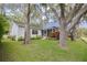 Well-maintained backyard with mature trees and a screened lanai, offering a private outdoor space at 3569 Oak Lake Dr, Palm Harbor, FL 34684