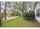 Charming front yard with mature trees, lush greenery, and partial view of the house at 3569 Oak Lake Dr, Palm Harbor, FL 34684