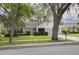 Charming single-story home featuring a manicured lawn and mature trees with moss at 3569 Oak Lake Dr, Palm Harbor, FL 34684
