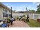 Charming backyard with brick-paved area, string lights, garden pots and white fencing at 35819 Diamond Head Ct, Zephyrhills, FL 33541