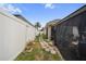 Landscaped backyard featuring a stone pathway, potted plants, and screened-in patio at 35819 Diamond Head Ct, Zephyrhills, FL 33541