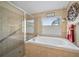 Relaxing bathroom features a soaking tub under a window and separate tiled shower with glass door at 35819 Diamond Head Ct, Zephyrhills, FL 33541