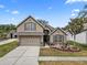 Charming home featuring a manicured lawn, a two-car garage, and lovely stone accents at 35819 Diamond Head Ct, Zephyrhills, FL 33541