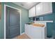 Well-equipped laundry room with washer, dryer, cabinets and gray painted door at 35819 Diamond Head Ct, Zephyrhills, FL 33541