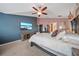 Bright and inviting main bedroom with a flat screen TV, ceiling fan, and a large bed at 35819 Diamond Head Ct, Zephyrhills, FL 33541