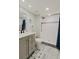 Well-lit bathroom featuring a shower with tile surround, patterned floor, and updated vanity at 400 Island Way # 1709, Clearwater Beach, FL 33767