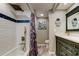 Charming bathroom featuring a shower/tub combo, patterned curtain, and updated vanity with marine themed decorations at 400 Island Way # 1709, Clearwater Beach, FL 33767