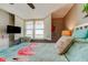 Bright bedroom featuring tropical bedding, shuttered windows with water views, and playful flamingo decor at 400 Island Way # 1709, Clearwater Beach, FL 33767