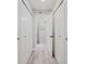 Hallway with white wood-look floors, coat closet and view to the bathroom at 400 Island Way # 1709, Clearwater Beach, FL 33767