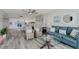 Bright open-concept living space with modern furnishings, including a blue sofa and dining area with wicker chairs at 400 Island Way # 1709, Clearwater Beach, FL 33767