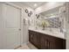 Bathroom with dual sinks and marble countertops, decorative art, and white-tiled floor at 4533 Eternal Prince Dr, Sun City Center, FL 33573