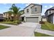 Two story home with a two car garage, beautiful landscaping and a palm tree in the front yard at 4533 Eternal Prince Dr, Sun City Center, FL 33573