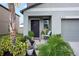 Charming front entrance featuring a black door, muted siding, and lush landscaping at 4533 Eternal Prince Dr, Sun City Center, FL 33573