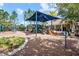 Community playground with swings, slides, and climbing equipment, all shaded by mature trees at 4533 Eternal Prince Dr, Sun City Center, FL 33573