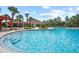 Beautiful community swimming pool featuring easy access stairs and lush landscaping and surrounding buildings at 4533 Eternal Prince Dr, Sun City Center, FL 33573