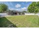 Expansive backyard with lush grass, a screened-in pool enclosure, and ample space for recreation at 4708 Ranch Grove Ct, Valrico, FL 33596