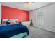 A bedroom with carpeted floors and a bold red accent wall and a guitar on display at 4708 Ranch Grove Ct, Valrico, FL 33596
