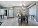 Open-concept dining area with large windows, wood-look tile and modern lighting at 4708 Ranch Grove Ct, Valrico, FL 33596