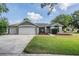 Charming single-story home with a well-manicured lawn and a three-car garage at 4708 Ranch Grove Ct, Valrico, FL 33596