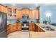 Well-equipped kitchen featuring wood cabinets, granite countertops, stainless steel appliances, and bright, natural lighting at 4708 Ranch Grove Ct, Valrico, FL 33596