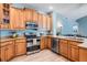 Spacious kitchen boasting wood cabinets, stainless steel appliances, granite countertops, and a seamless layout for cooking at 4708 Ranch Grove Ct, Valrico, FL 33596