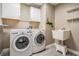 A functional laundry room featuring washer, dryer, sink, shelving, and ample storage at 4708 Ranch Grove Ct, Valrico, FL 33596