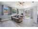 Bright living room featuring wood-look tile floors, vaulted ceilings, and sliding glass doors leading to a screened pool at 4708 Ranch Grove Ct, Valrico, FL 33596
