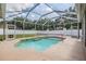 Sparkling pool with volleyball net in a screened enclosure, perfect for summer fun and relaxation at 4708 Ranch Grove Ct, Valrico, FL 33596