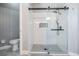 Modern glass enclosed shower with gray tile accents, black fixtures, and a built-in niche at 4708 Ranch Grove Ct, Valrico, FL 33596