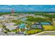 Aerial view of a community featuring a lake, clubhouse, pool, tennis courts, and numerous homes surrounded by greenery at 4831 Rosatti Rd, Wesley Chapel, FL 33543