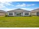 Beautiful backyard with patio space and lush green grass leading up to the home at 4831 Rosatti Rd, Wesley Chapel, FL 33543