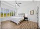 Light and airy bedroom featuring wood floors, a ceiling fan, and shuttered windows offering a peaceful view at 4831 Rosatti Rd, Wesley Chapel, FL 33543