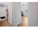 Hallway view to bath and bedroom featuring wood floors, fan and sun-filled window at 4831 Rosatti Rd, Wesley Chapel, FL 33543