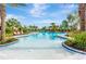 A beautiful community pool area with palm trees, lounge chairs, and meticulously manicured landscaping at 4831 Rosatti Rd, Wesley Chapel, FL 33543