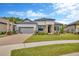 Charming single-story home with well-manicured lawn, stone accents, tile roof, and paver driveway at 4831 Rosatti Rd, Wesley Chapel, FL 33543
