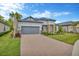 Charming single-story home with well-manicured lawn, stone accents, tile roof, and paver driveway at 4831 Rosatti Rd, Wesley Chapel, FL 33543