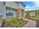 Inviting front porch with stone columns, comfortable seating, and lush landscaping, creating a welcoming entrance at 4831 Rosatti Rd, Wesley Chapel, FL 33543