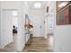 Bright hallway featuring wood-look tile flooring, white walls, and glass table with decorative items at 4831 Rosatti Rd, Wesley Chapel, FL 33543