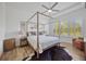 Spacious main bedroom with a four-poster bed, wood-look floors, and shuttered windows at 4831 Rosatti Rd, Wesley Chapel, FL 33543