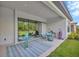 Covered patio with modern furniture, a glass table, and a view of the lush backyard at 4831 Rosatti Rd, Wesley Chapel, FL 33543