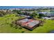 Aerial view of tennis courts next to grassy area, a pond with fountain, and condo buildings with water view at 4872 Beach Se Dr # D, St Petersburg, FL 33705