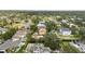 This neighborhood aerial highlights a vacant lot with mature trees, near homes with private pools and manicured gardens at 5029 W Dickens Ave, Tampa, FL 33629