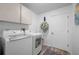 Efficient laundry room featuring modern washer and dryer units and overhead storage at 5193 Boyle Ter, Port Charlotte, FL 33981