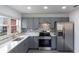 Bright kitchen featuring gray cabinets, stainless steel appliances, and decorative tile backsplash at 5210 S 80Th St, Tampa, FL 33619