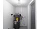 A water heater is housed in a small room next to a closed door at 5210 S 80Th St, Tampa, FL 33619
