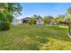 Expansive backyard featuring a lush lawn, mature trees, and a screened patio area at 5296 Slater Rd, Spring Hill, FL 34608